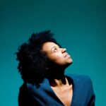 Striking portrait of a woman looking upwards with dramatic studio lighting.
